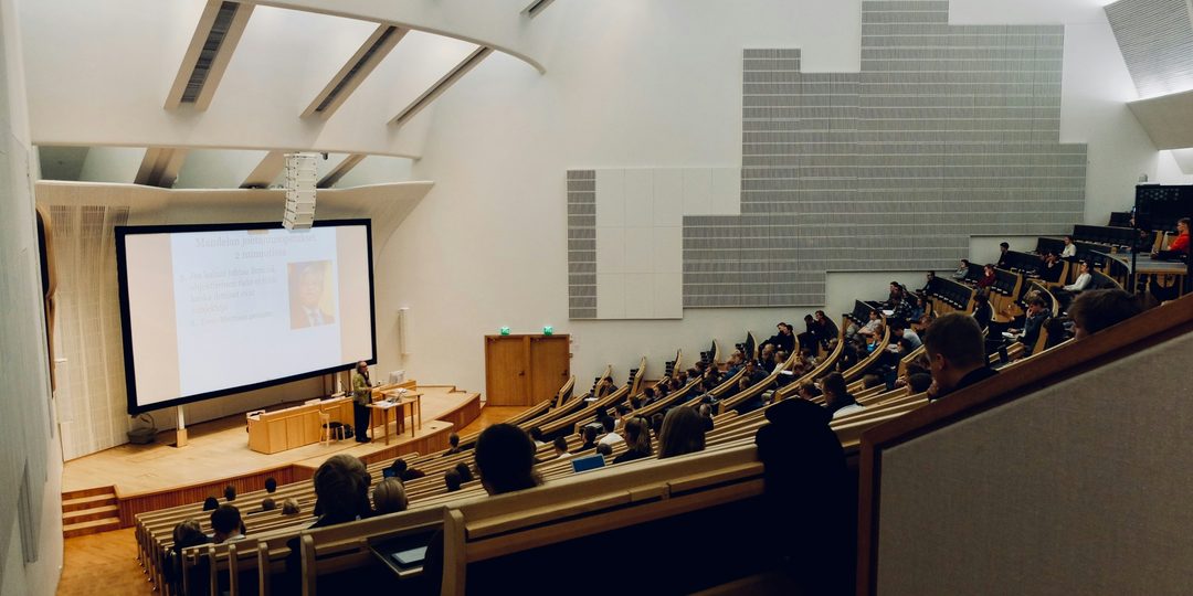 Foredrag i gymnasium-auditorium med projektor